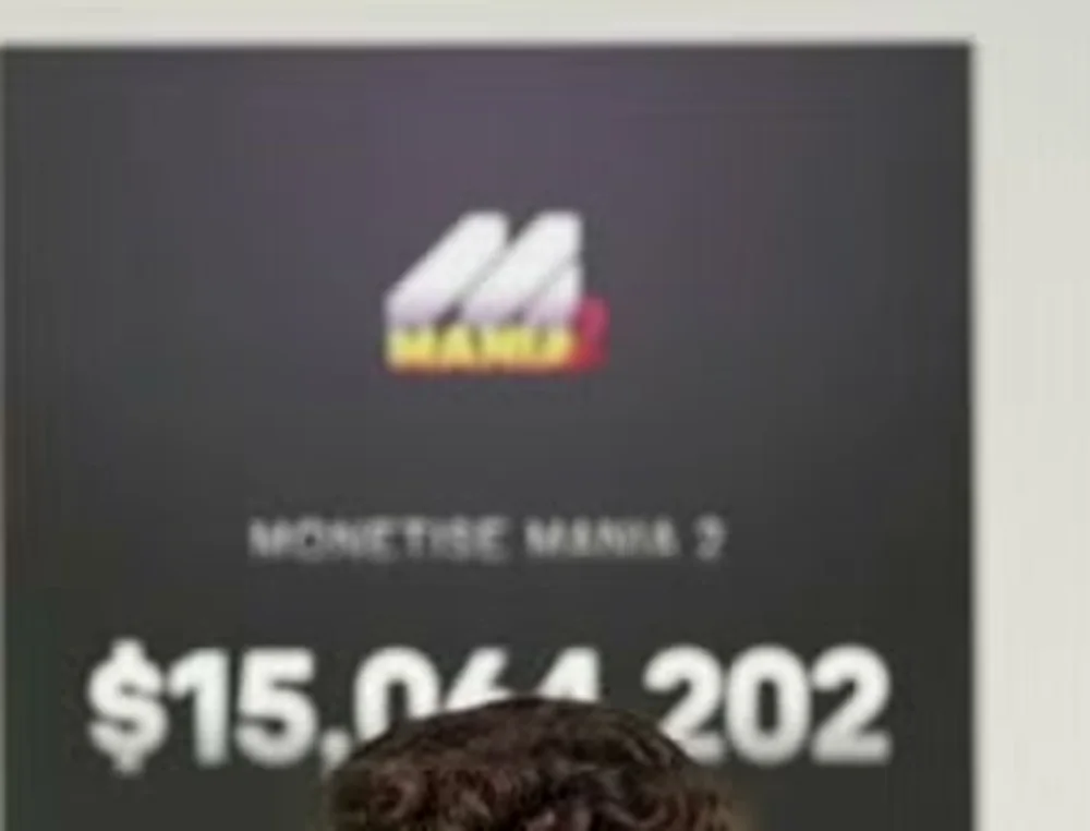 Set backdrop from the September 8 session reading MONETISE MANIA 2 with a total of $15,064,202 earned beneath the Mania 2 logo.